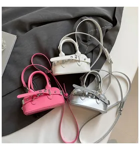 Detailed set of mini shell bags in white, pink, and silver with glossy patent leather finish