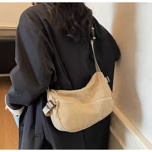 Detailed back view of a beige crescent nylon crossbody bag with an adjustable wide strap