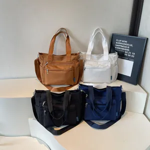 Large nylon tote bags with multiple zippers in caramel, beige, black, and navy blue colors