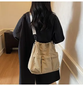 Detailed view of the khaki nylon tote bag with drawstring closure and multiple utility pockets