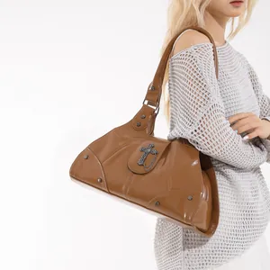 Brown vintage gothic tote bag with metal cross and studs, worn on shoulder