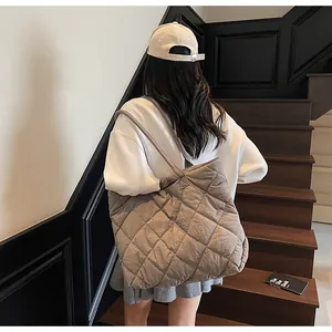 Brown quilted tote bag shown in a lifestyle street style setting on a staircase