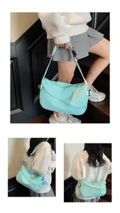 Detail view of mint green nylon crossbody bag with dual zippers and adjustable strap