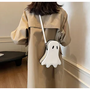 Détail d'un sac bandoulière fantôme blanc mignon porté avec un trench-coat beige classique