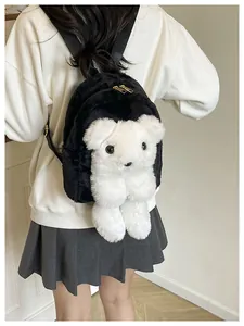 Detail of plush black shoulder bag with a 3D white bear doll and gold zipper hardware