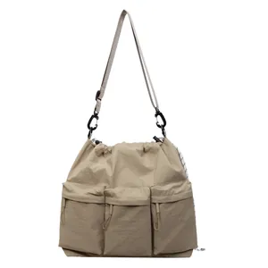 Khaki multi-pocket utility tote bag with drawstring closure and adjustable strap