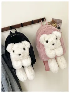 Detailed view of pink and black plush bear tote bags hanging on a wooden rack