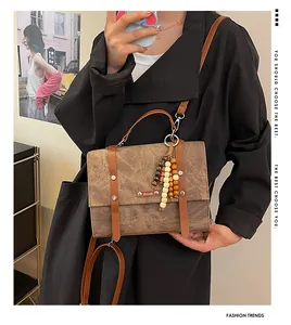Sac à main vintage marron en cuir avec pompon en perles de bois et bandoulière réglable