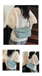 Detail of light blue nylon dumpling bag with adjustable wide strap and soft texture