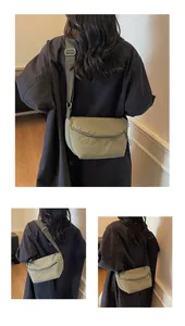 Detail showing the olive green nylon crossbody bag texture and metallic adjustment buckle