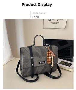 Détail de la mallette gris anthracite avec perles et ordinateur en arrière-plan