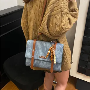 Sac à dos bleu vintage avec lanières en cuir marron et pendentif à pompon en perles de bois