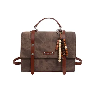 Sac cabas vintage marron en toile avec texture marbrée et anses en cuir sur fond blanc