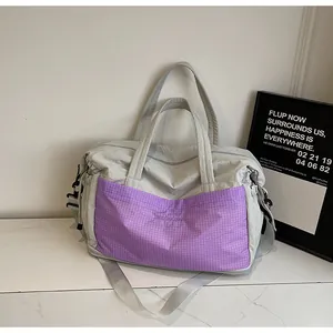 Detail of large capacity travel bag in grey with purple check pocket and sturdy strap