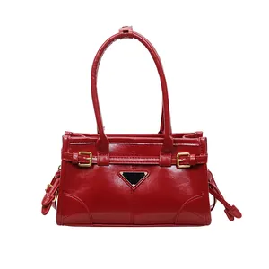 Glossy red retro shoulder bag with top handle and iconic triangular metal logo detail