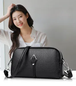 Détail du sac en cuir de vachette noir avec ornement pétale argenté et texture grainée