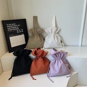 Minimalistische bucket bags met trekkoord in vijf kleuren op een trapsgewijze display