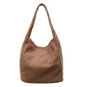 Brown fuzzy fleece tote bag with a soft hobo silhouette and integrated handle design
