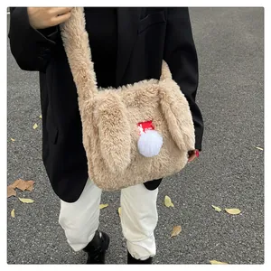 Detail of plush rabbit ear shoulder bag with soft beige faux fur and pom-pom decor