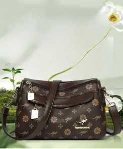 Détail du sac à main marron imprimé avec logo kangourou sur une surface miroir