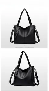 Close-up of black litchi grain leather tote bag with vertical stitching and metal hardware
