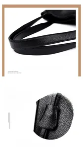 Detail of black pebbled leather handbag with sturdy dual handles and square charm tag