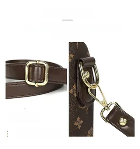 Détails de la boucle dorée brillante et du cuir gaufré floral sur un sac marron