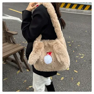 Detail of the soft light brown plush shoulder bag with cute rabbit ears and fluffy white pompom