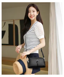 Détail du sac à bandoulière noir grainé avec boucle métallique argentée élégante