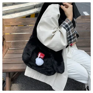 Detail of black faux fur tote bag featuring a red rabbit logo tag and white pompom charm