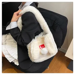Detail of soft white faux fur tote bag with cute rabbit ears and fluffy pom-pom charm