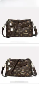 Détail du motif floral sur sac bandoulière marron avec logo kangourou doré