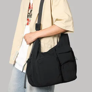 Large black nylon crossbody tote bag with multi-pocket utility design for travel