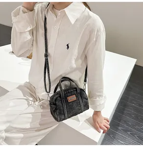 Details der schwarzen Denim-Handtasche im Vintage-Stil mit Leder-Patch und Doppelgriffen