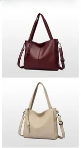 Detail view of lychee texture faux leather handbags in burgundy and creamy white colors