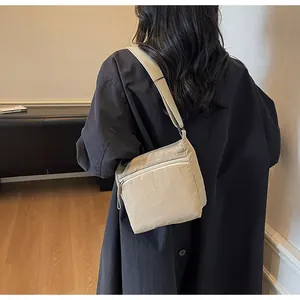 Detailed side view of the light brown nylon crossbody bag with adjustable wide strap
