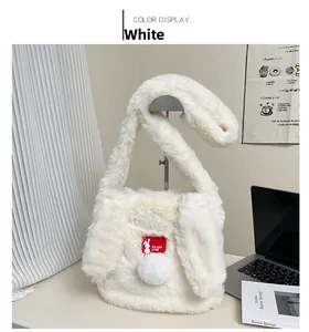 Detail of white plush shoulder bag with bunny ear straps and soft pom-poms for winter