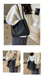 Close-up of black litchi grain leather tote bag with vintage patterned wide strap