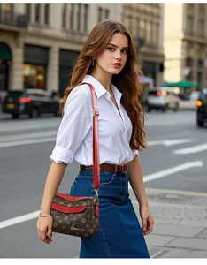 Détail du sac bandoulière avec motif floral, rabat en cuir rouge et logo kangourou doré