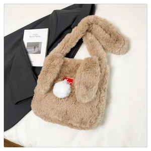 Detail of soft brown plush rabbit shoulder bag with long ears and white pom-pom