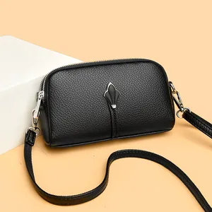 Détail du sac coquille en cuir grainé noir avec motif feuille argentée et double zip