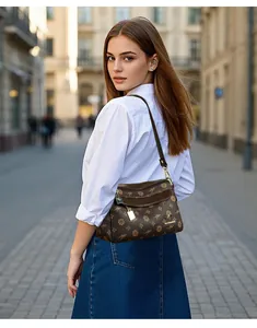 Détail du sac bandoulière imprimé avec logo kangourou doré et motifs floraux de qualité