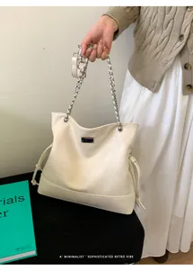 Detail of cream tote bag featuring textured PU leather and silver metal chain strap