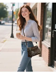 Détail d'un sac bandoulière marron texturé avec motif floral et finitions dorées