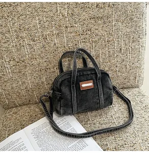 Nahaufnahme einer verwaschenen Denim-Mini-Tasche mit Lederetikett auf einem Sitz