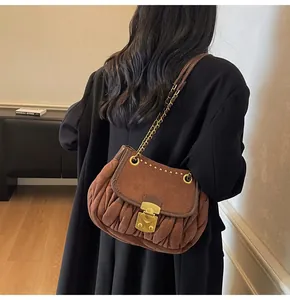 Detail of vintage brown pleated shoulder bag with gold chain strap and metal lock buckle