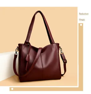 Close-up of deep burgundy litchi-grain leather tote with adjustable shoulder strap