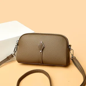 Sac bandoulière marron en cuir grainé avec double fermeture éclair et finitions argentées