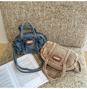 Nahaufnahme von Retro-Zylinderbeuteln aus Denim in Blau und Braun auf einem Stuhl