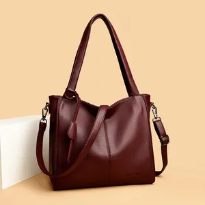 Close-up of wine red litchi grain leather tote bag with brand logo and metal hardware